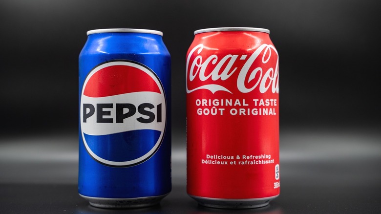 Cans of Pepsi and Coca-Cola next to each other.