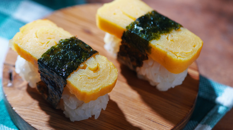 Cooked egg tamago sushi on a wooden plate