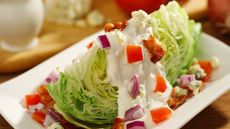 wedge salad with blue cheese dressing poured on top