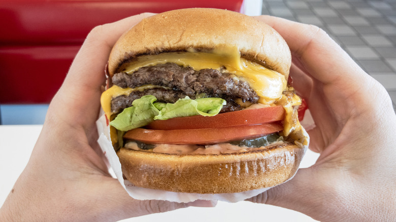 Hand holding in-n-out style burger