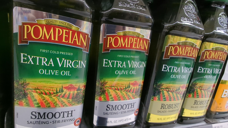 A row of Pompeian olive oils sitting on the grocery store shelf.