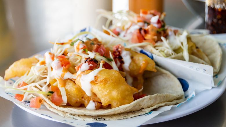 Closeup of fried fish tacos on white plate