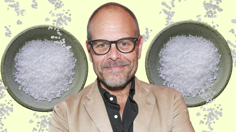 Alton Brown smiling with small bowls of salt in the background