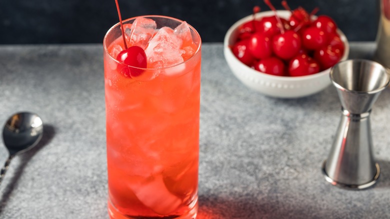 A Shirley Temple mocktail with a bowl of maraschino cherries
