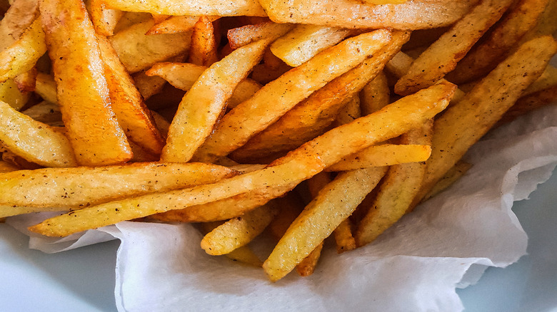 A close up of seasoned french fries in a takeout bag