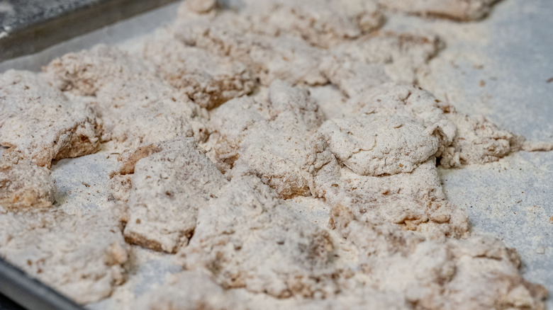 Tray of bone-in chicken pieces tossed in flour