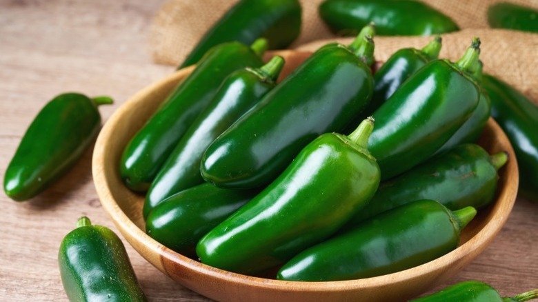 Smooth-skinned green jalapeños, indicating a milder heat.