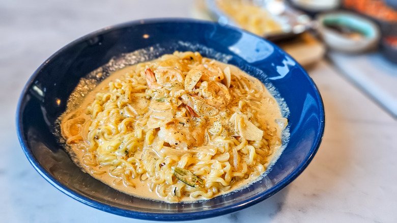 Cheesy ramen tteokboki in a blue bowl.