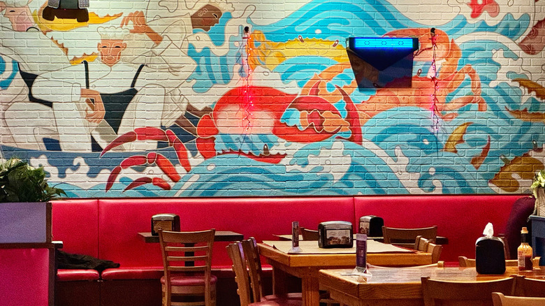 Mural inside The Fatty Crab with chairs, tables, and booths