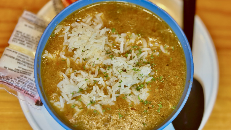 Gumbo soup from the Fatty Crab in a bowl on top of a plate with crackers on the side