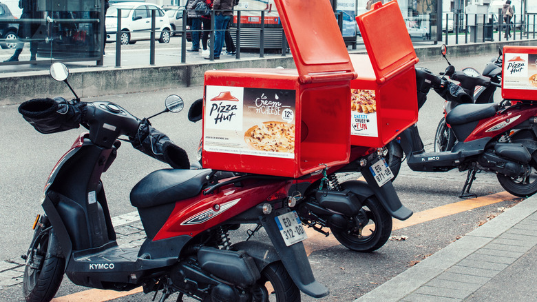 Mopeds with Pizza Hut delivery boxes on the backs