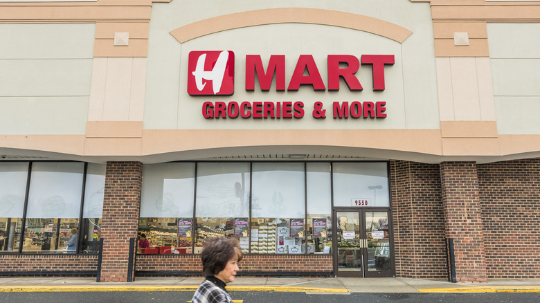 The exterior of an H Mat location with a woman walking outside of it