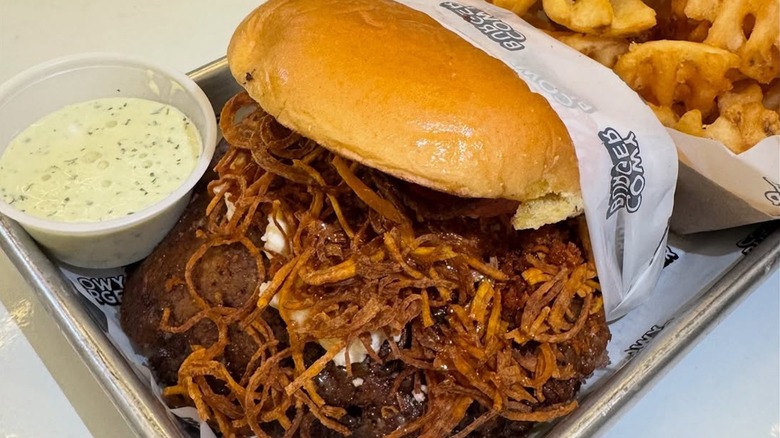Cabrito burger from Miami's Cowy Burger on a tray next to waffle fries