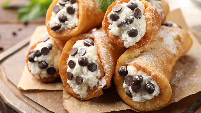 Chocolate chip cannoli stacked on brown paper
