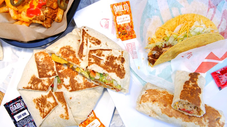 Taco Bell sauces, tacos, burritos, and Crunchwraps on paper wrappers