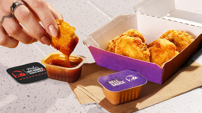 Dipping a Taco Bell chicken nugget into Mike's Hot Honey Diablo Sauce