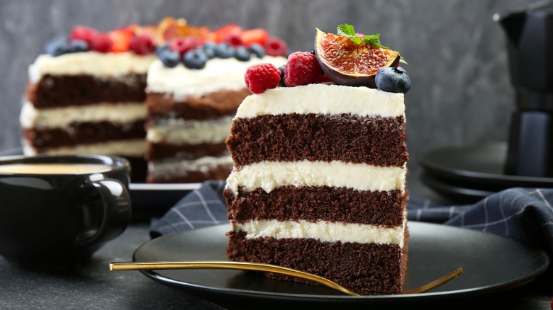 Slice of layered cake with whole cake in background