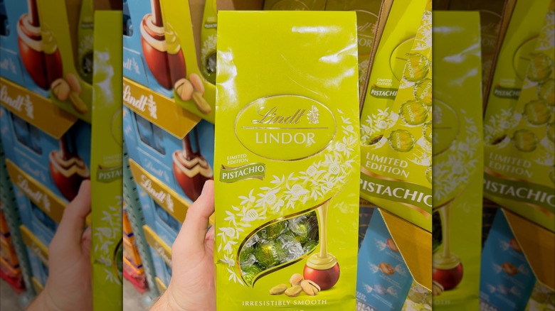 Hand holding a bag of Lindt Lindor pistachio truffles