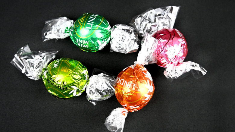Four multicolored Lindt truffles on black