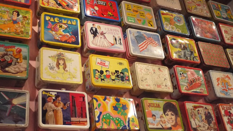 Vintage metal lunch boxes hung on wall for display