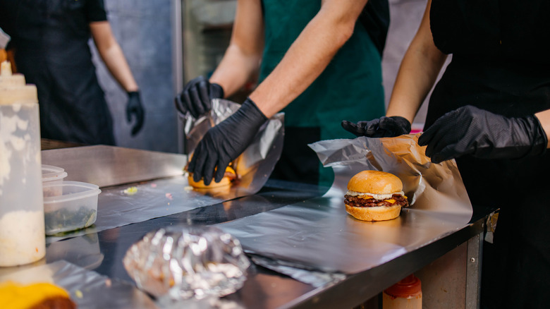 Fast food employees making burgers.
