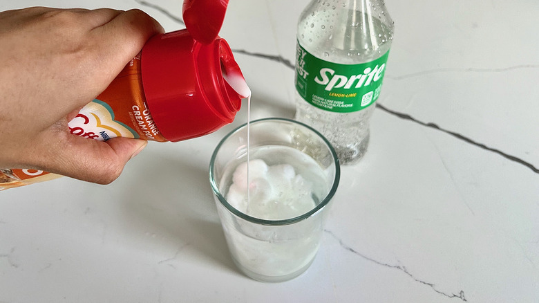 coffee creamer, coffee in a cup with a spoon, and a tea kettle
