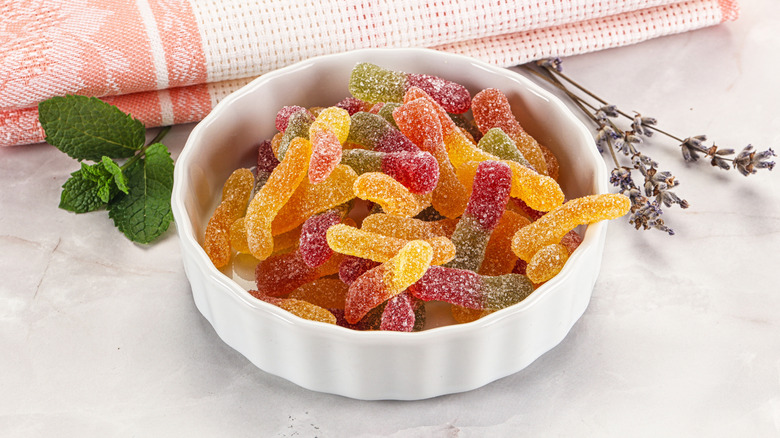 Sour gummy worms in white bowl