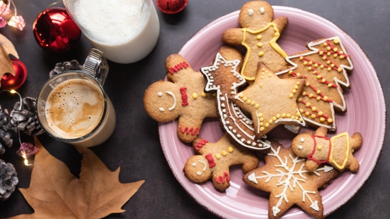 Festive gingerbread cookies on a plate next to a cup of coffee.