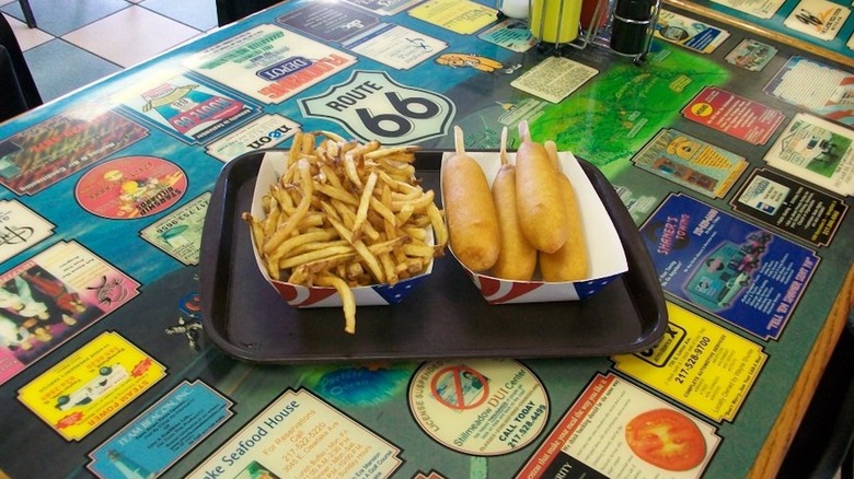 corn dogs and fries on a black tray at the Cozy Dog Drive In