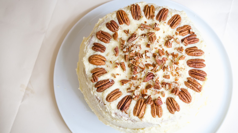 Top view of whole cake decorated with pecans and cream cheese frosting