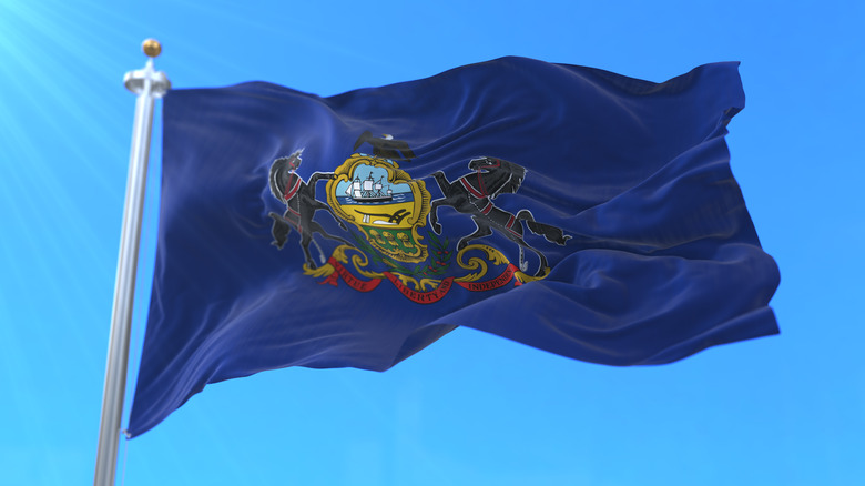 Pennsylvania state flag waving with blue sky in back