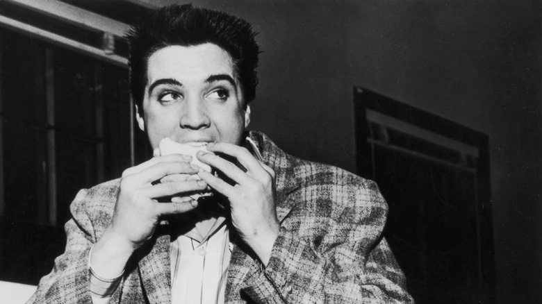 Elvis eating a sandwich in black and white