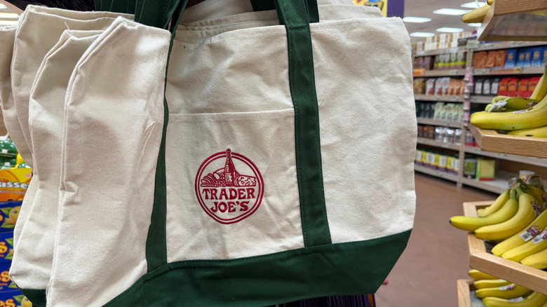 A rack holding several Trader Joe's canvas tote bags in the store.