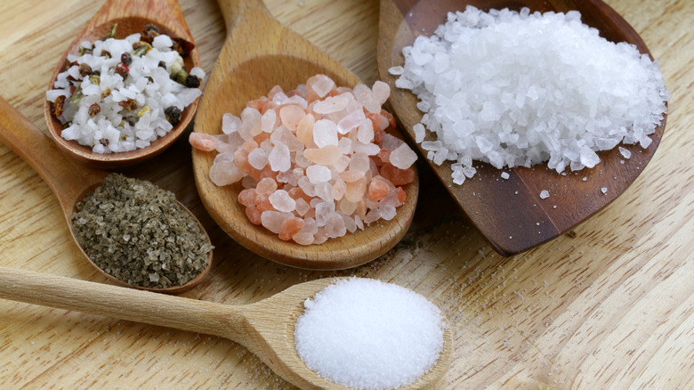 Spoons with different types of salts on a table