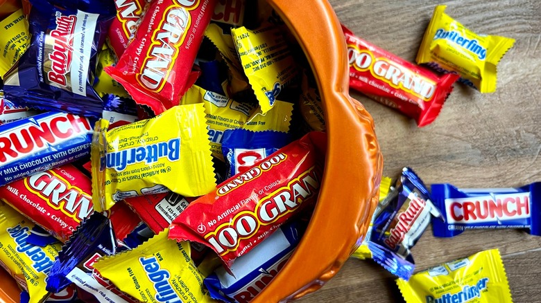 Miniature candy bars in and around a bowl