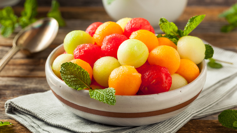 melon ball salad in bowl with mint sprigs