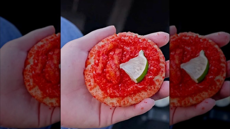 Hand holding a Crumbl flamin' lime crunch cookie