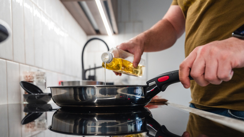 A man pouring oil into a pan