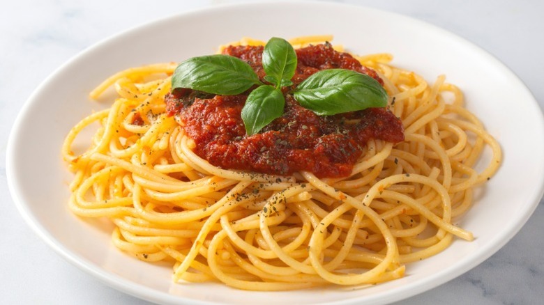 A plate of spaghetti with tomato sauce.