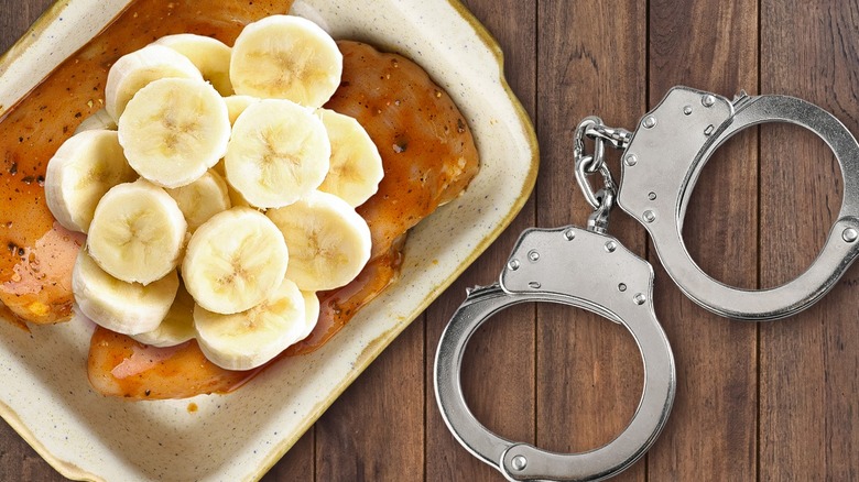 Banana slices on cooked chicken in a casserole dish next to handcuffs on a table