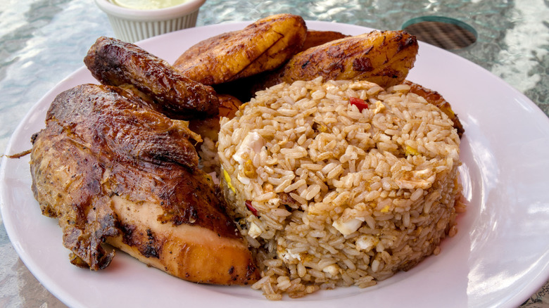 Fried plantains with grilled chicken and fried rice on a plate