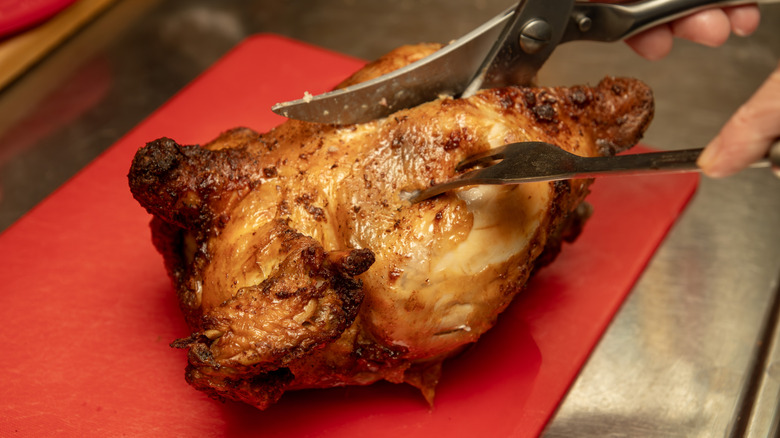 cutting roasted chicken with shears