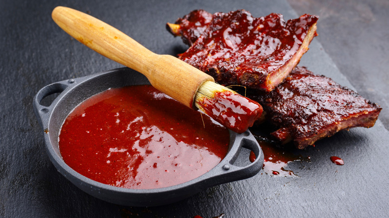 bbq sauce in small black bowl with ribs