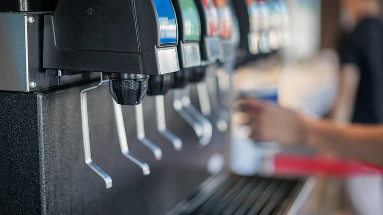 soda fountain with hand filling a cup