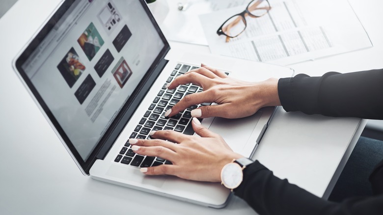 hands of a woman researching on a laptop
