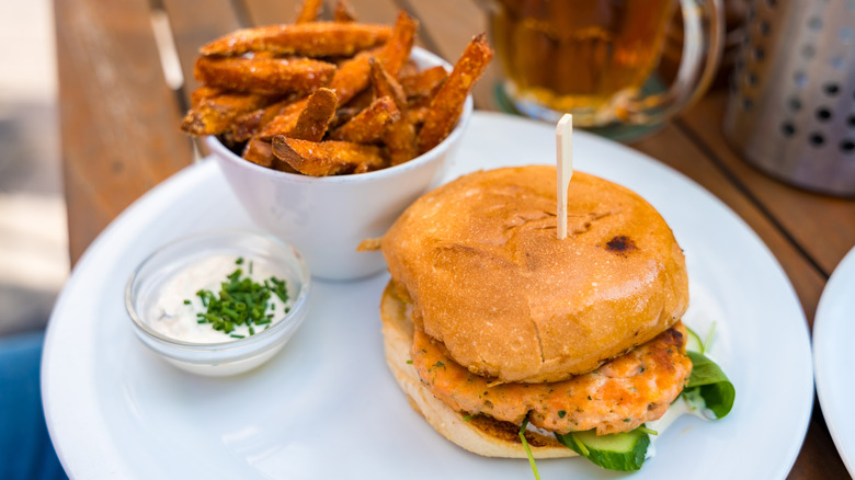 salmon patty on bun with sweet potato fries