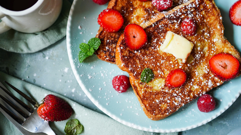 French toast topped with butter, sugar, and strawberries
