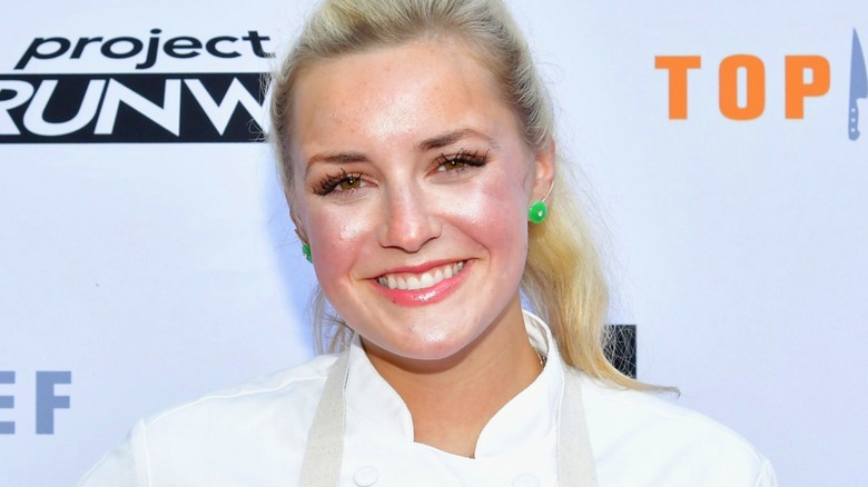 Kelsey Barnard Clark smiles in an apron at an event