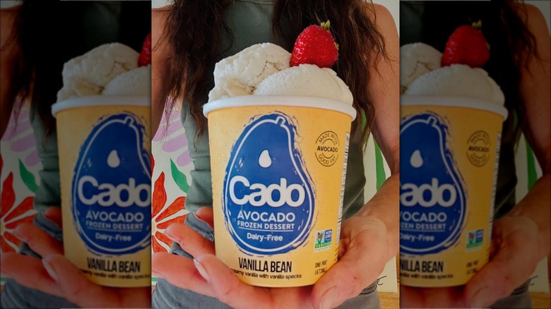 Hand holding pint of Cado vanilla ice cream