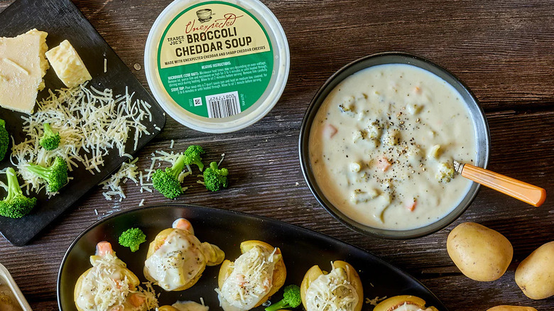 Trader Joe's Unexpected Broccoli Cheddar Soup alongside potatoes, cheese, and broccoli